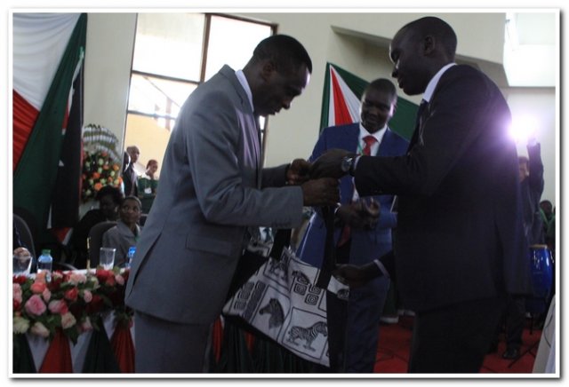 prof.ogechi handing over a present to h.e. governor mandago during the launch